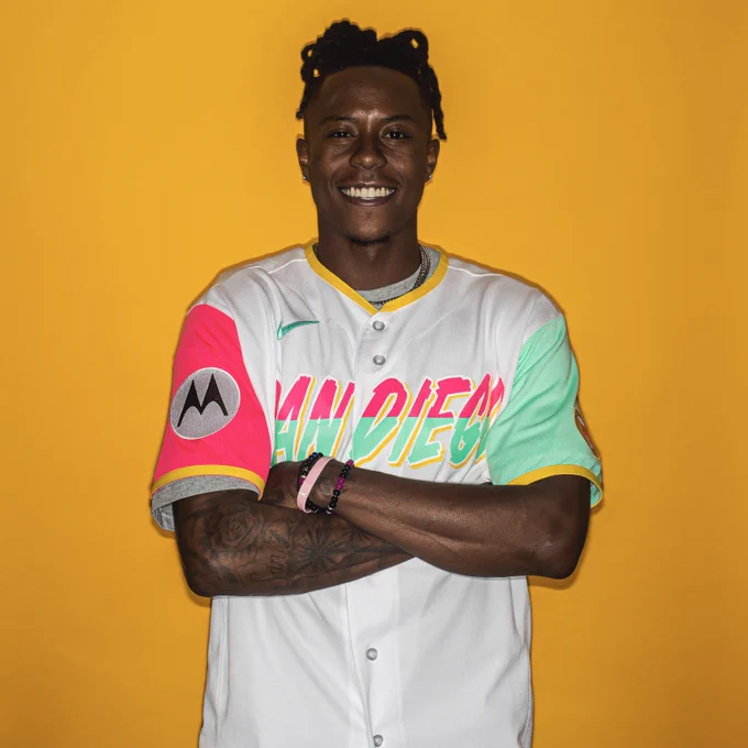 Rashid Shaheed posing in front of a yellow backdrop. He is wearing the Padres City Connect jersey and is posing with his arms crossed as he smiles for the camera. Rashid Shaheed, New Orleans Saints 2023 NFL All-Pro and San Diego native, will throw the game’s Ceremonial First Pitch tonight.