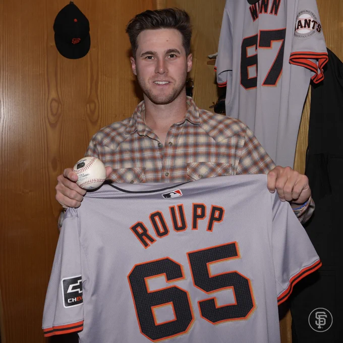 Landen Roupp smiling while holding the ball and jersey from his debut