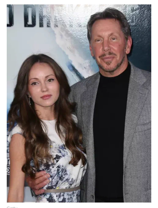 Larry Ellison with his hand around the waist of someone who could be his great grand daughter