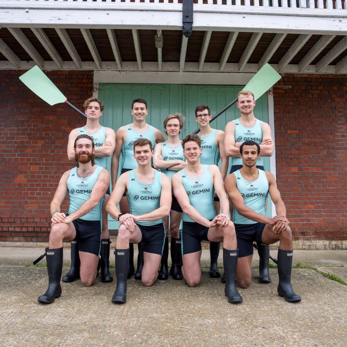 Men's Blue crew pose together with two crossed blades.