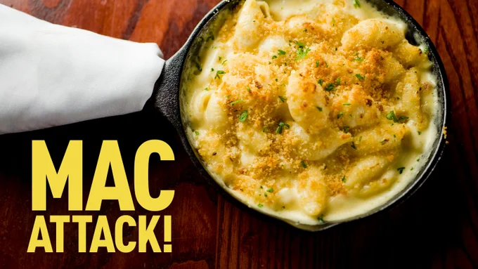 [text] "Mac Attack!" in the left bottom corner of a picture of mac and cheese in a skillet. 