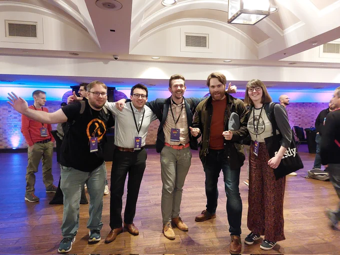 5 smiling faces of some of the organizers and members of the Rust and Cpp Cardiff meetup, hanging out at RustNationUK