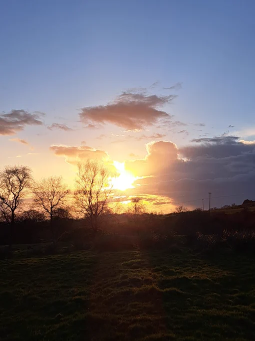 Fiery sunset with blue skies and grey clouds 