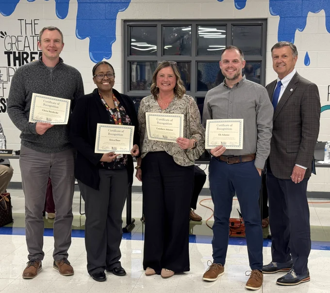 Four adults holding certificates and smiling next to Dr. Snowden