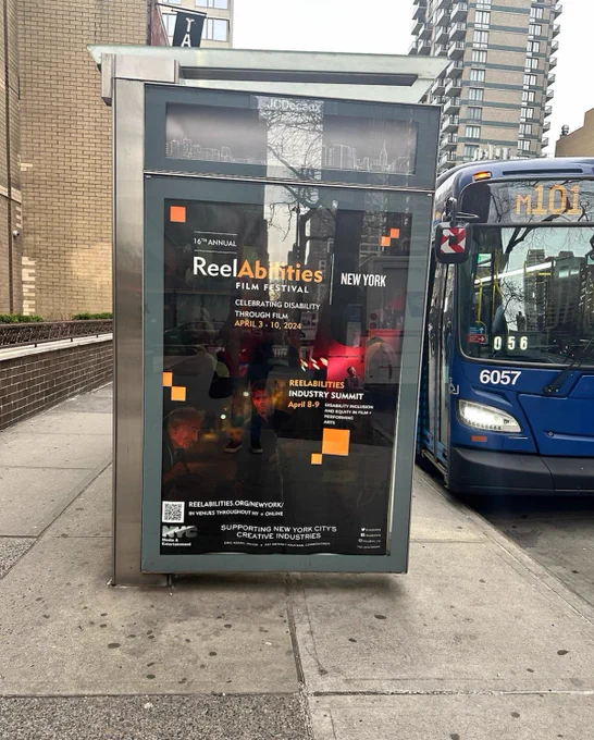 An image of a bus shelter with a poster of the 16th Annual ReelAbilities Film Festival: New York.