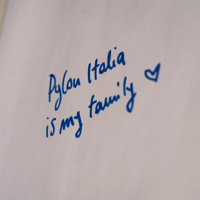 Photo of someone writing on a whiteboard "PyCon Italia is my family"