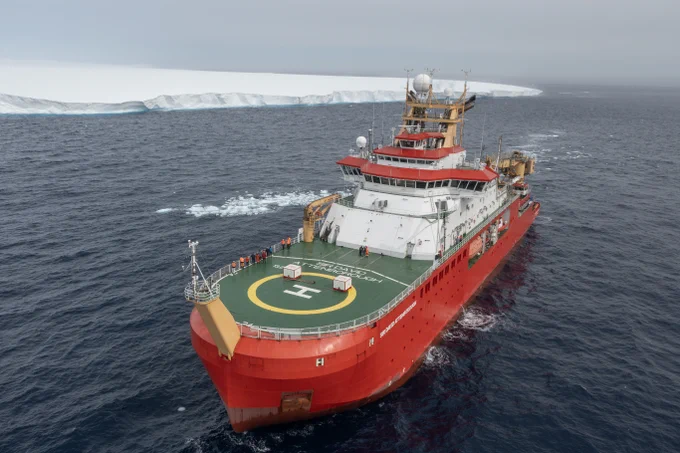 Ship in front of a big iceberg