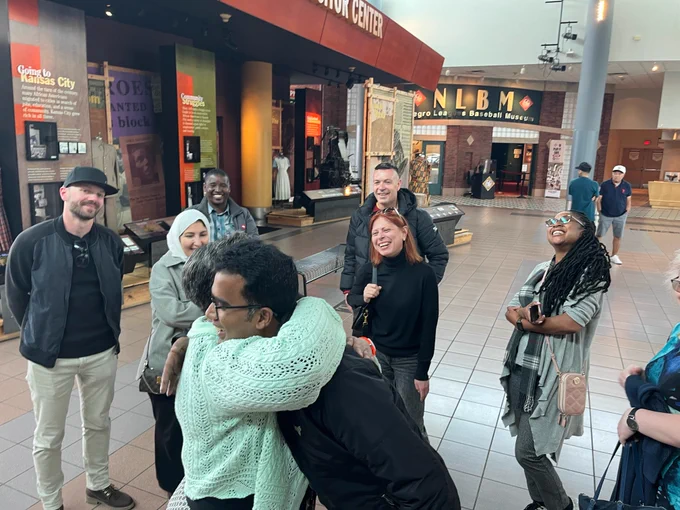 Muriel Boyd, Docent and Volunteer Manager for the American Jazz Museum in Kansas City, embraces Professor IV G. M. Rakibul Islam from Bangladesh and welcomes his fellow International Visitor Leadership Program participants during their visit to the museum.