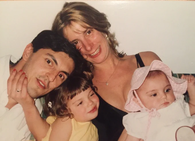 a slightly faded photograph of an infant and toddler with their parents. 