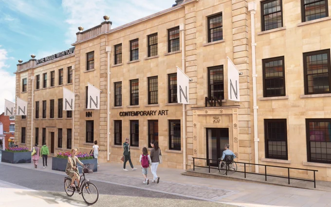 Large sandstone brick building with multiple white flags presenting the NN logo. A public art work on the roof reads ‘in the middle with you’. People move past the building at street level.