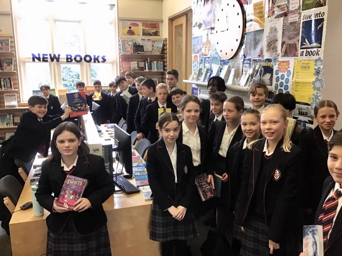 Year 7 children with books in the Library