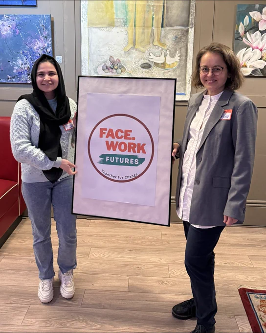 Masoma and Halyna holding up a sign with the Facework Futures logo on it