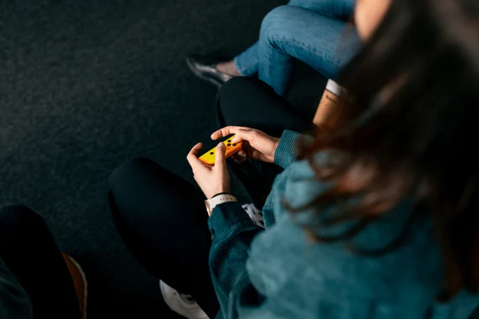 eine Person, die einen gelben Controller hält