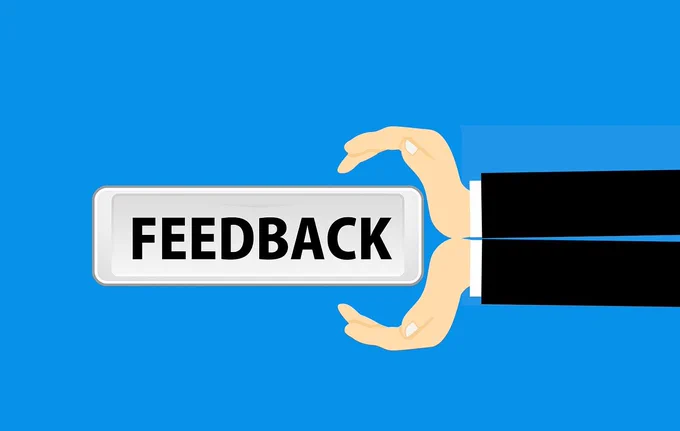 A pair of arms and hands coming out of the images from right to left holding a sign saying 'feedback'. Image by Mohamed Hassan from Pixabay