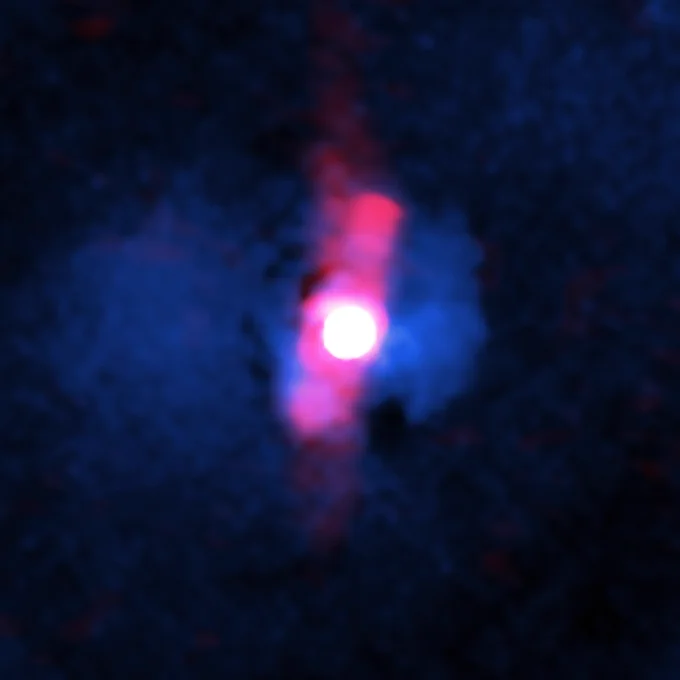 This composite image shows a quasar, a rare and extreme class of supermassive black hole, that's located about 3.4 billion light-years from Earth.

At the center of the image is a bright, white, circular light, similar to the beam of a flashlight if it was pointed directly toward you. A fuzzy, bar-shaped structure of red-colored radio light, slightly larger than the width of the white light, surrounds the circular structure. The red bar also extends above and below the white light, stretching in a somewhat straight line from about the one o'clock position to the seven o'clock position on a clock face.

On either side of the red bar, X-ray light is present as blue, wispy clouds of hot gas that are brighter closer to the red and white features. The brighter clouds represent more dense gas.
