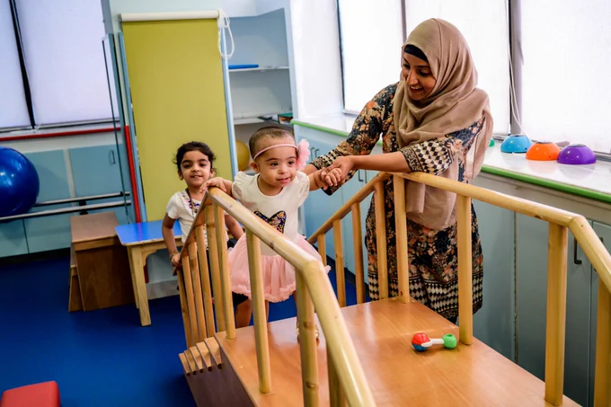 Silah, 1 (center) during her rehabilitation and training process at the Down Syndrome Program Center (KDSP) in Karachi, Pakistan.
