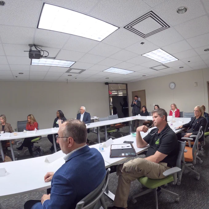 A group of people seated  and looking at a presenter.