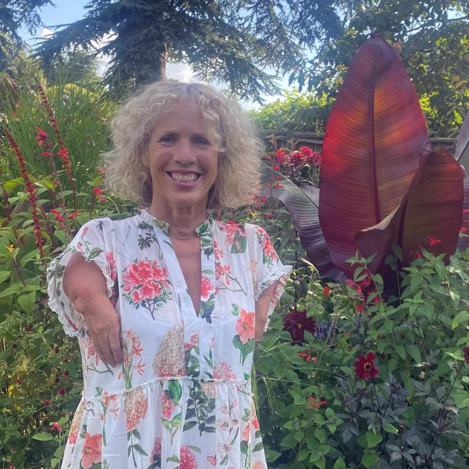 Sue Kent standing next to one of the Red Borders at Hidcote.