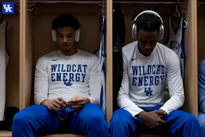 Tre Mitchell and Antonio Reeves sitting with their head down in the locker room. 