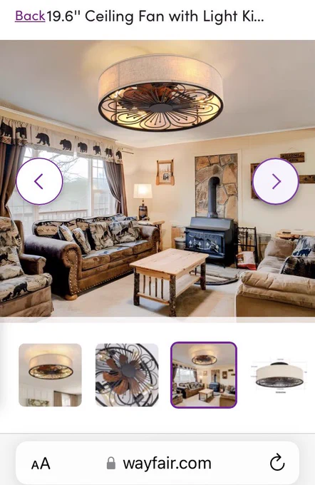 Picture of a ceiling fan in a living room from Wayfair which has lights and a fan enclosed in a light shade.