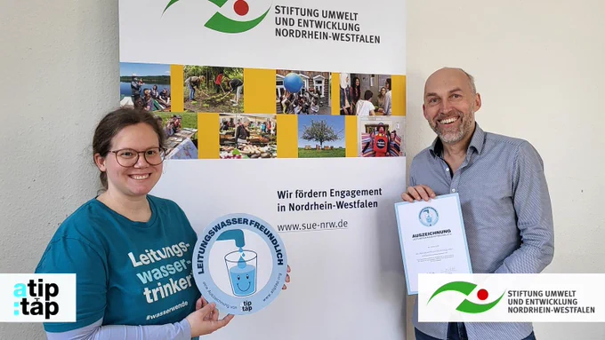 Frank Griesel von der Stiftung Umwelt und Entwicklung Nordrhein-Westfalen freut sich über die Auszeichnung als leitungswasserfreundlich, die von Tine Wecker von a tip: tap übergeben wird.
