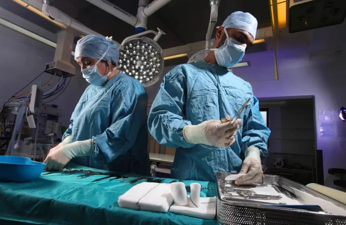 A photo of two healthcare workers in a medical theatre setting.