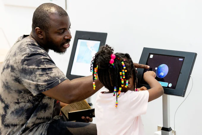 Image of a father and daughter at an exhibition. 