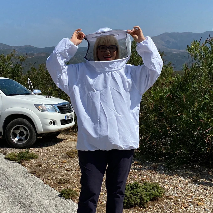 Chef Maria Loi donning bee keeper clothing at Strovies of Kissamos in the mountains of Crete⁠