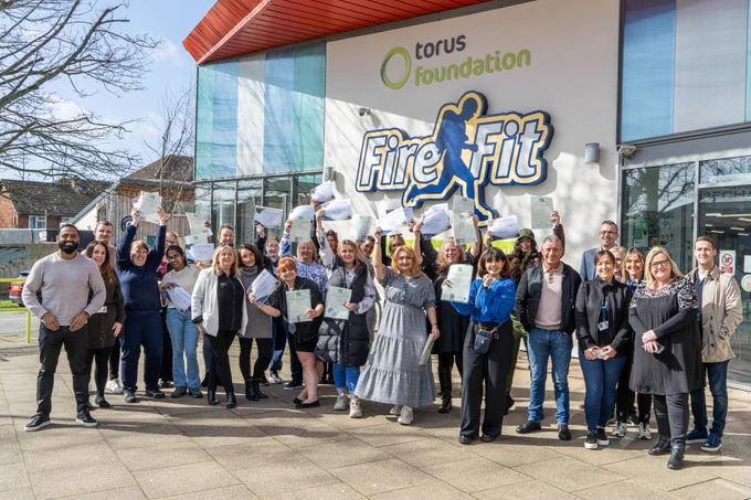 A group of learners are celebrating completing the Women in Construction training held in Liverpool and are waving their certificates 