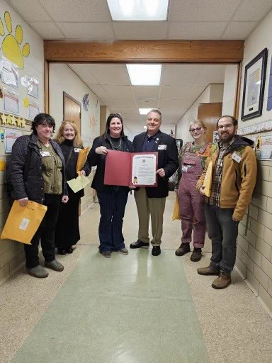 Image of Commissioner Tom DiBello and others holding an Agricultural Literacy Week proclamation 