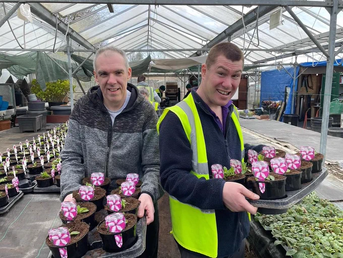 Two Heaton Fold students showing off their hard work with completing the planting of trailing petunia plugs!