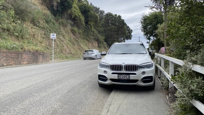 Large BMW badly parked on a footpath