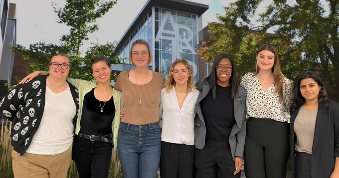 A group photo of Public Issues Anthropology MA students in front of an ARTS building at the University of Waterloo