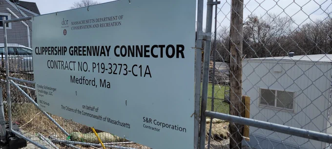 Photo of constuction fence with Clippership Greenway Connector construction sign on it.