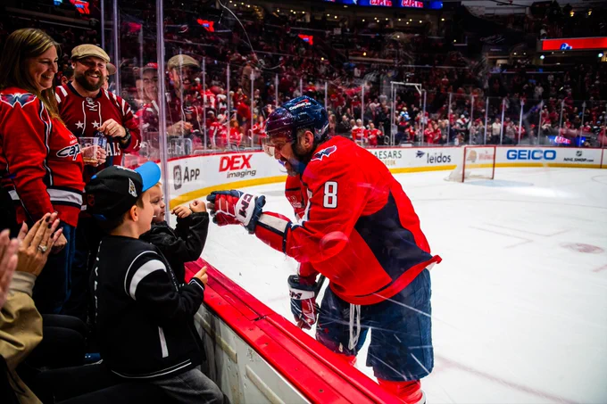 Alex Ovechkin gives his kids a fist bump on the glass. 