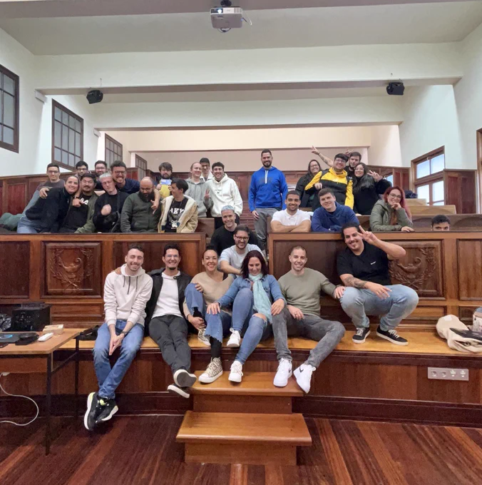 En la misma sala anterior y las mismas personas del equipo pero ahora es una foto más informal donde se puede ver como se hacen bromas, incluso uno de ellos se ha agachado de forma que solo se ven sus ojos 