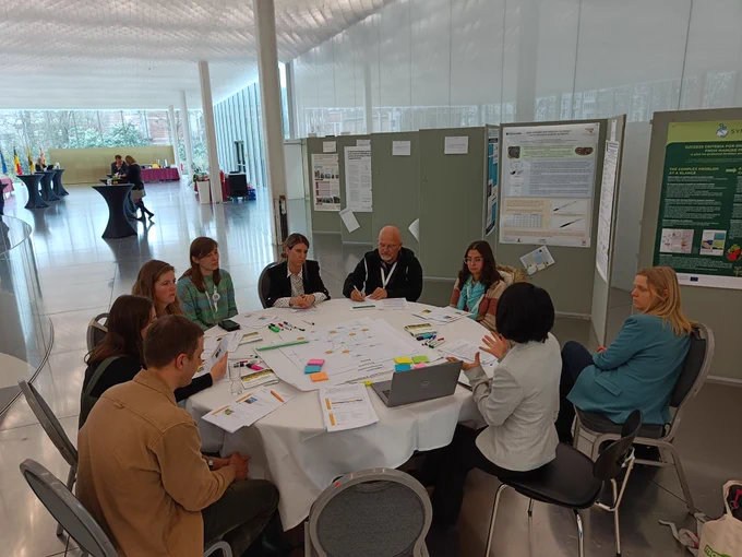 Seven people sitting around a table