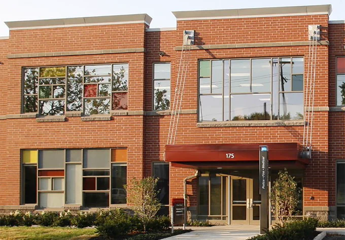 A section of a two-story, brick-fronted building with a red awning over the doors. The building is the Schoenbaum Family Center in Columbus, Ohio, home to Ohio State University's Crane Center for Early Childhood Research and Policy.