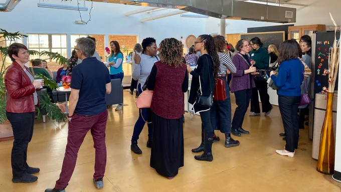 Group of individuals mingling and talking at FREE Center event