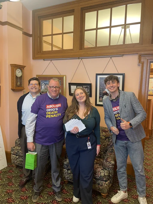 Two advocates from Ignite Peace, Ben and Peter, smile with members of Senator Bill DeMora’s Legislative team. They are holding up postcards from his constituents asking him to continue to support the abolition of Ohio’s Death Penalty.