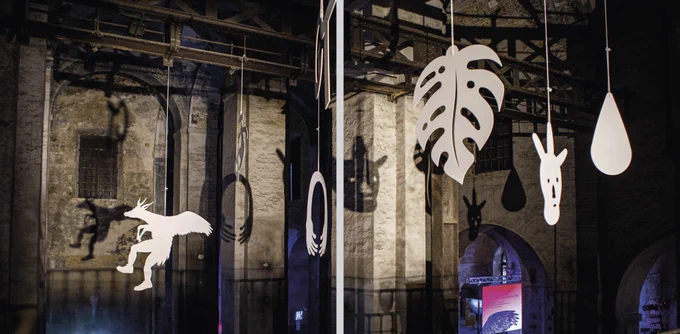 paper figures hang from the ceiling of the exhibition venue
