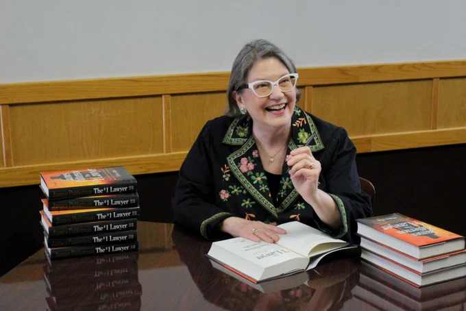 MSU Alumni and author Nancy Allen smiling while signing copies of her new book "#1 Lawyer" 