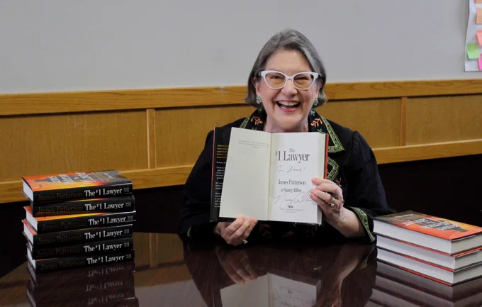 MSU Alumni and author Nancy Allen smiling while signing copies of her new book "#1 Lawyer" 