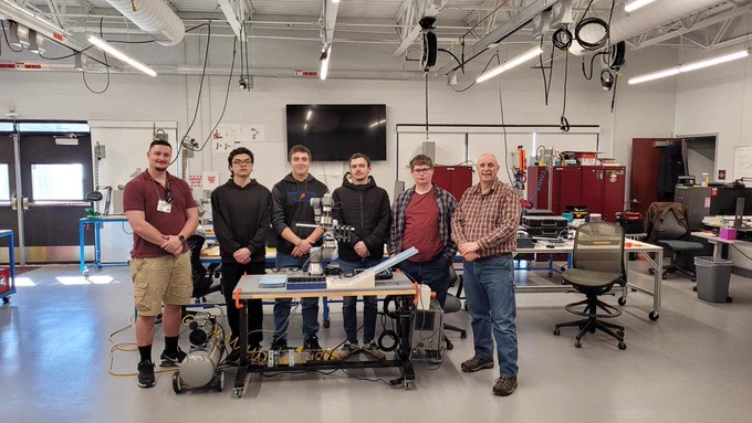 Mechatronics students with instructor and advisory committee member with their prototype.