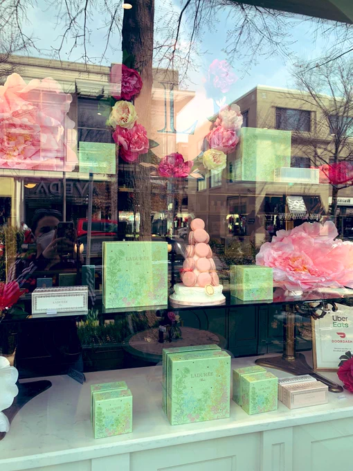 Ladurée store window front with pastel macarons, flowers, and boxes displayed in Bethesda, MD.