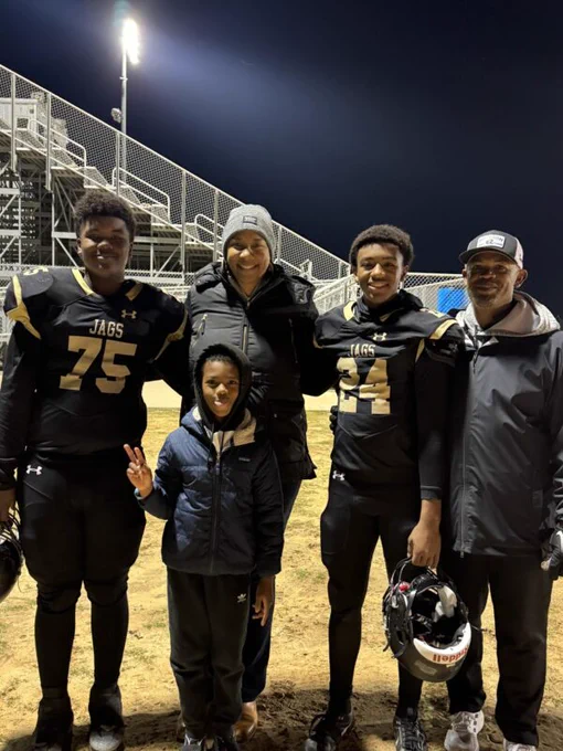 A present-day photo of Ronald and Zenarae Antoine with their three sons at a football game.