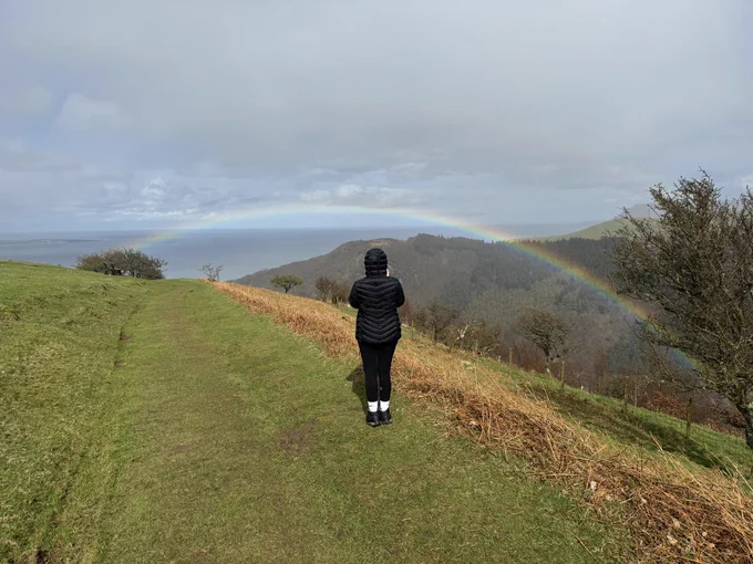 A wide shot of Jos back and a very close rainbow