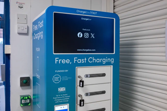 A photo of the new mobile phone charging unit. It's a rectangular box with a screen and has small cubby holes with keys for patients to lock their phone in securely. 