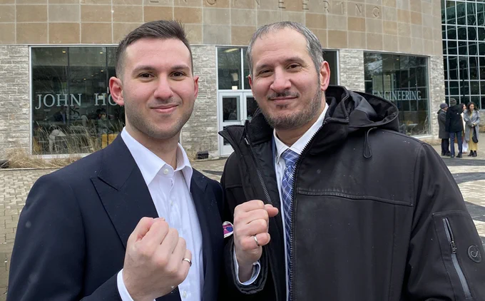 Rocc and Domenico pose outside JHE holding their hands in fists showing off their Iron Rings