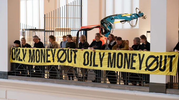 Protesters at the Science Museum holding a yellow banner that reads 'Oily Money Out'